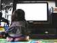 young child gazes at a TV