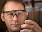 Brett Savoie holds a transparent polymer film