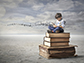 a kid sitting on a stack of books reading