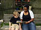 a lady and child sitting on a bench reading a book