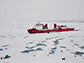 science team working on an ice station in front of the icebreaker XueLong