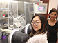 Rong Zhang (left), holds a high pressure diamond anvil cell inside a glovebox
