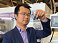 Zheng Chen holds vials of recycled cathode particles